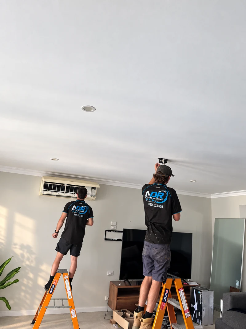 NDR technicians working beside an indoor air conditioning unit